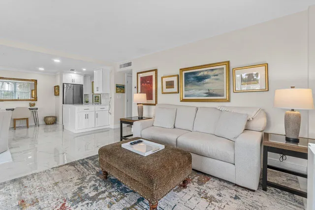 a living room with furniture and view of kitchen