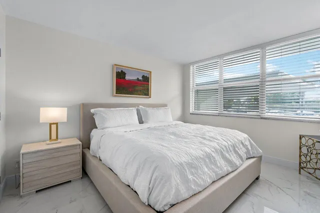 a bedroom with a bed and a large window