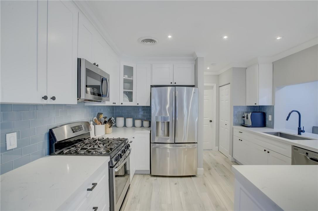 4117 McKinley Street Hollywood, FL 33021 - Photo 13 of 52 a kitchen with kitchen island granite countertop a sink stove and refrigerator