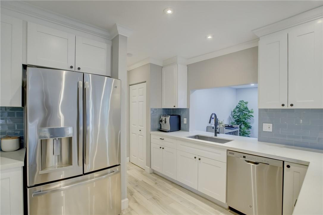 4117 McKinley Street Hollywood, FL 33021 - Photo 14 of 52 a kitchen with a refrigerator sink and white cabinets