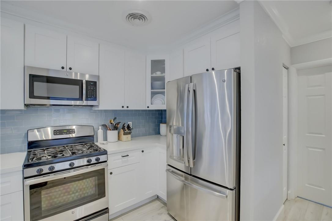 4117 McKinley Street Hollywood, FL 33021 - Photo 15 of 52 a kitchen with stainless steel appliances white cabinets and a stove top oven
