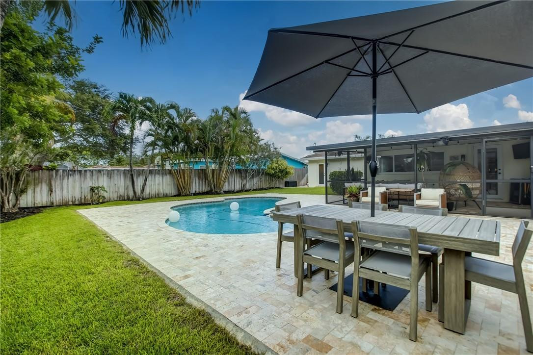 4117 McKinley Street Hollywood, FL 33021 - Photo 51 of 52 a view of a backyard with a table and chairs under an umbrella