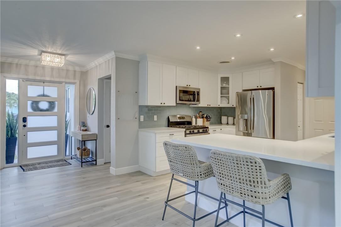 4117 McKinley Street Hollywood, FL 33021 - Photo 10 of 52 a kitchen with stainless steel appliances a refrigerator and a stove top oven