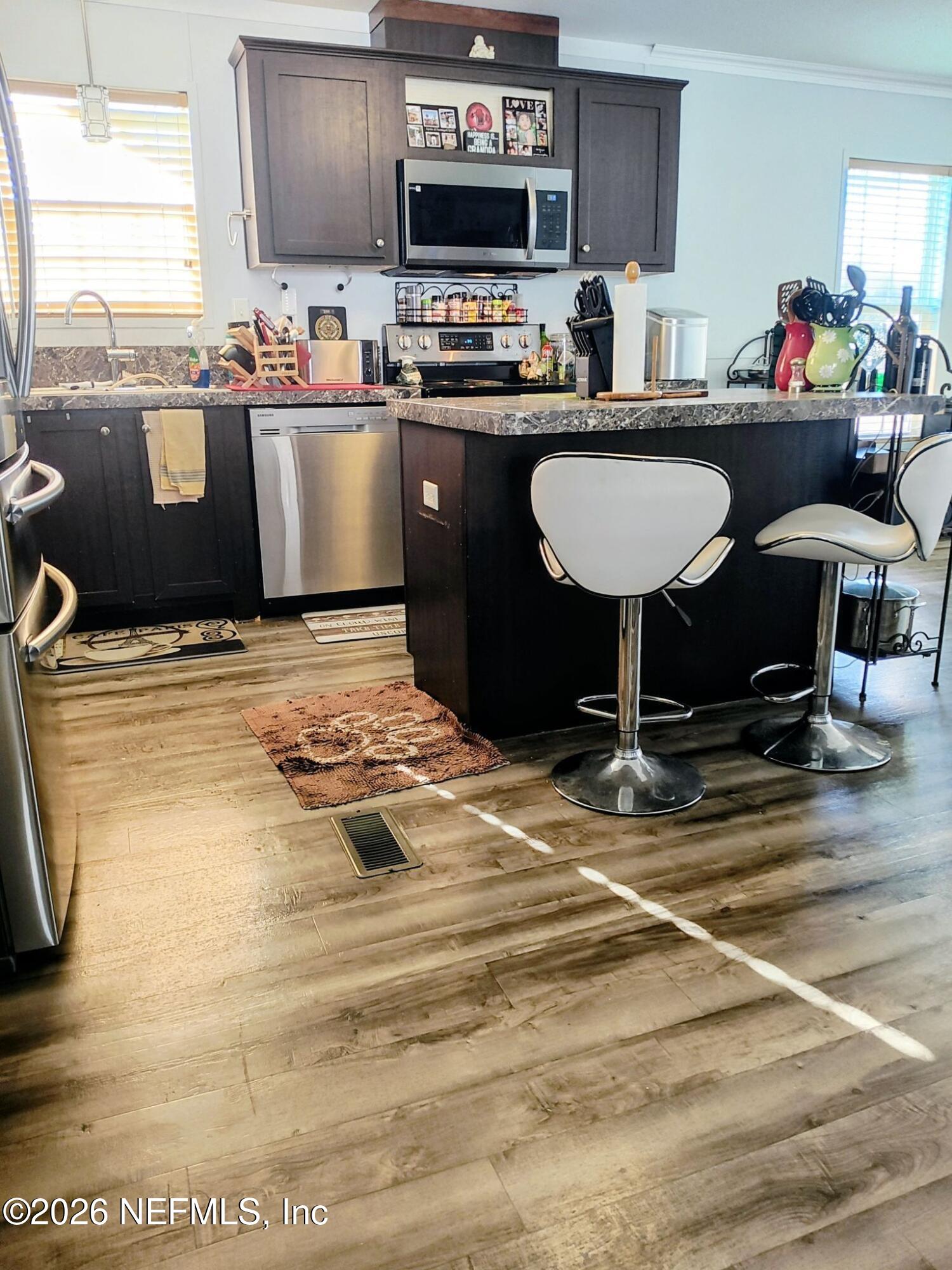 137 Lewis Street Edgewater, FL 32141 - Photo 2 of 42 a kitchen with kitchen island granite countertop a sink cabinets and a counter top space
