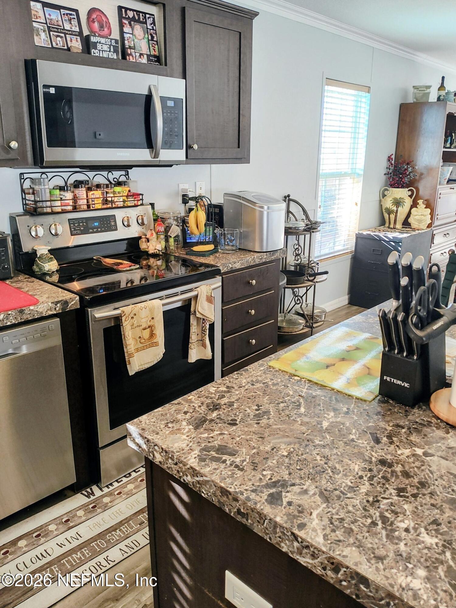 137 Lewis Street Edgewater, FL 32141 - Photo 6 of 42 a kitchen with a stove and a microwave