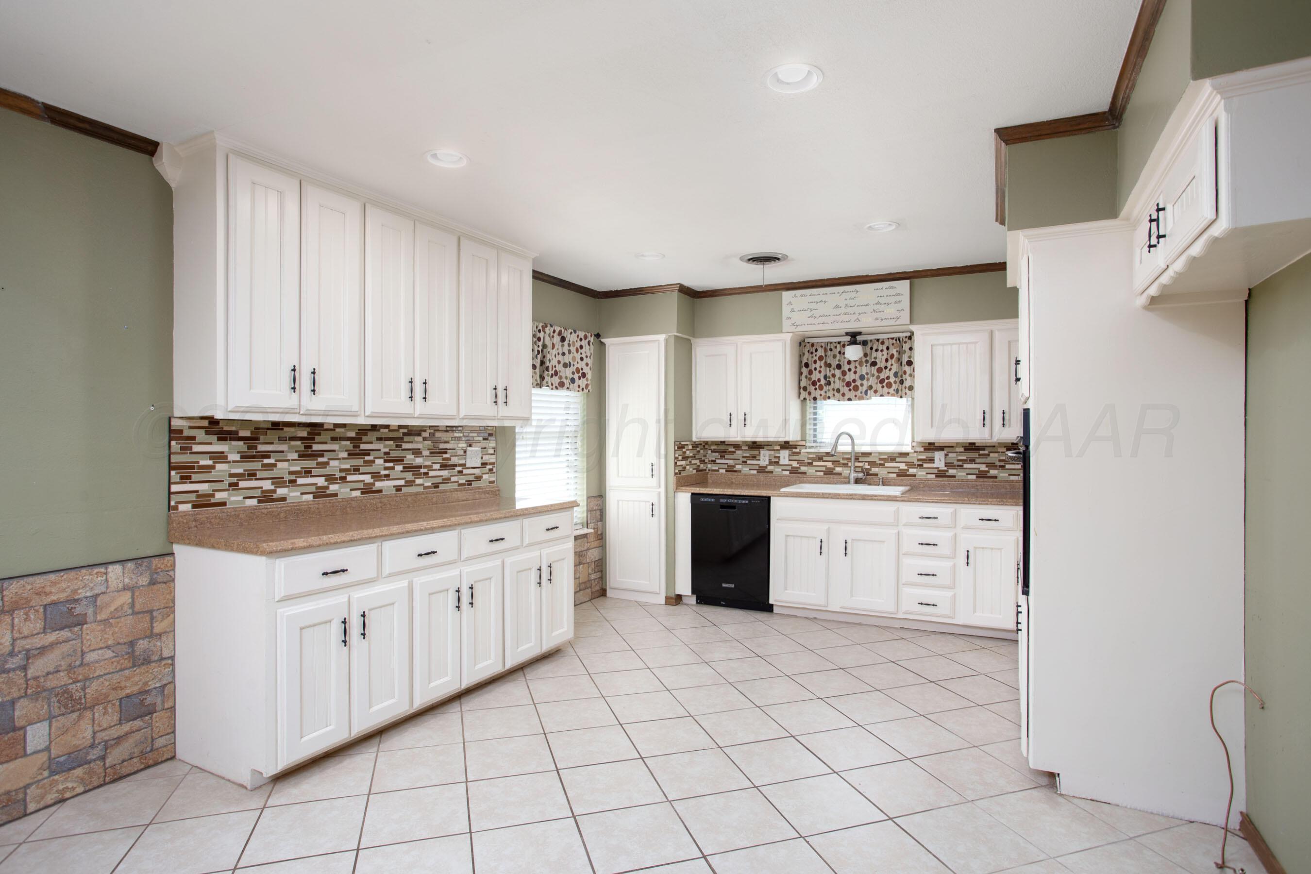 3729 Wayne Street Amarillo, TX 79109 - Photo 12 of 30 a kitchen with granite countertop white cabinets and white appliances