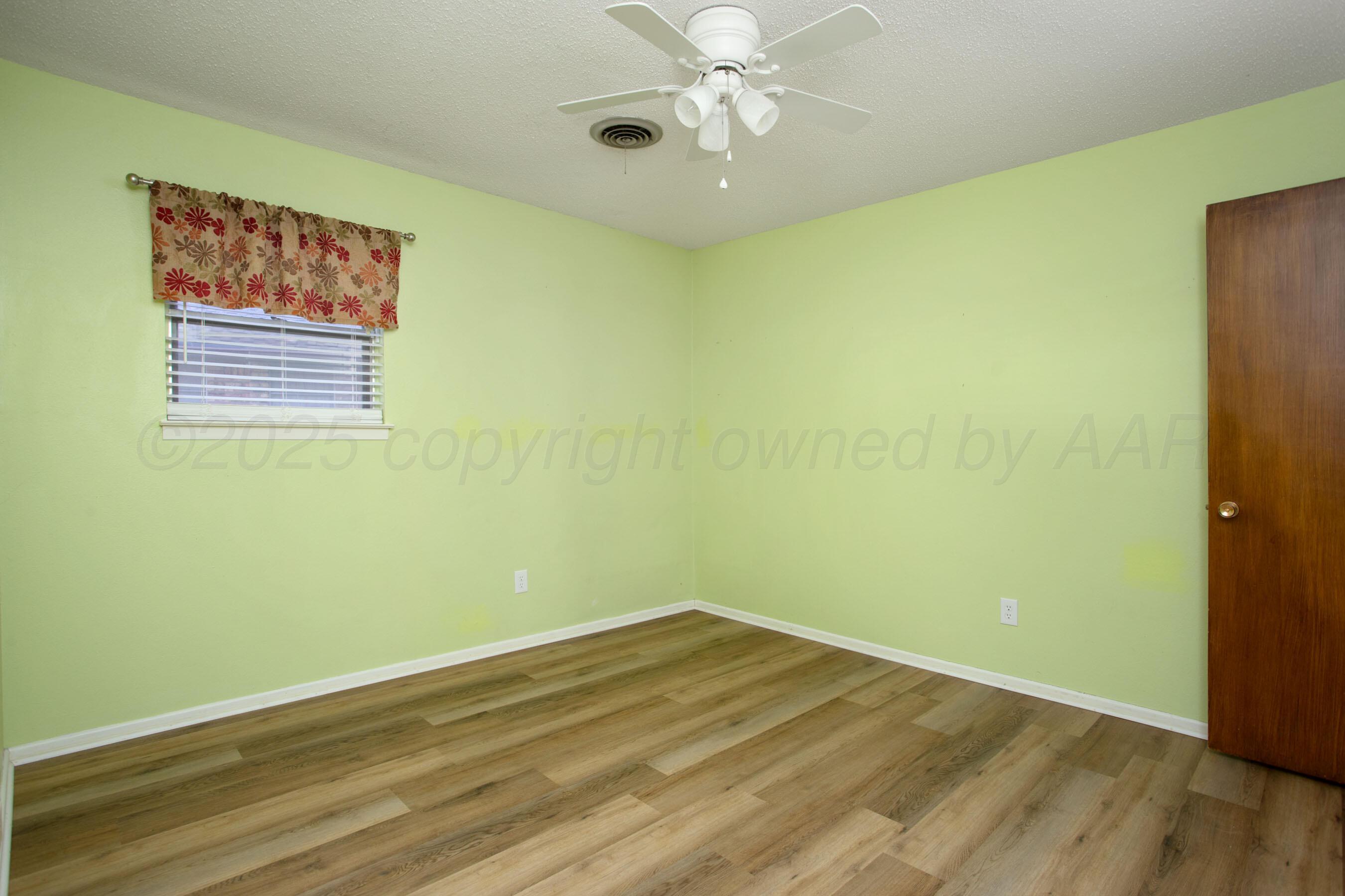 3729 Wayne Street Amarillo, TX 79109 - Photo 23 of 30 a view of an empty room with wooden floor and a ceiling fan