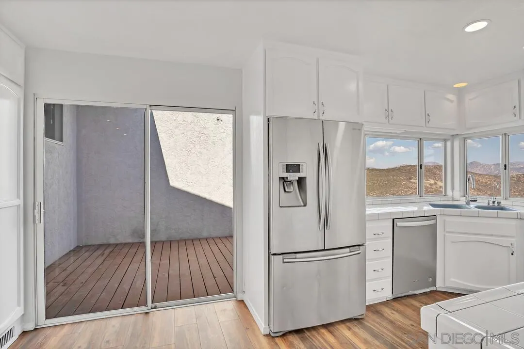 12040 Rocoso Road Lakeside, CA 92040 - Photo 15 of 56 a white refrigerator freezer sitting inside of a kitchen