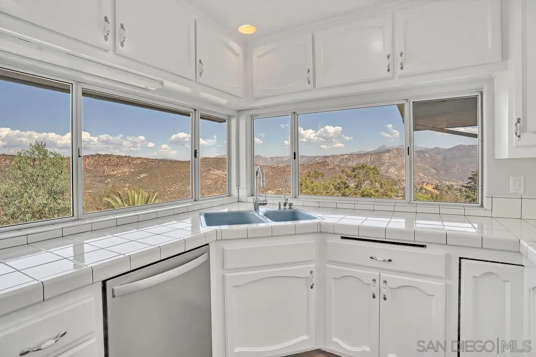 12040 Rocoso Road Lakeside, CA 92040 - Photo 16 of 56 a kitchen with appliances cabinets and a large window
