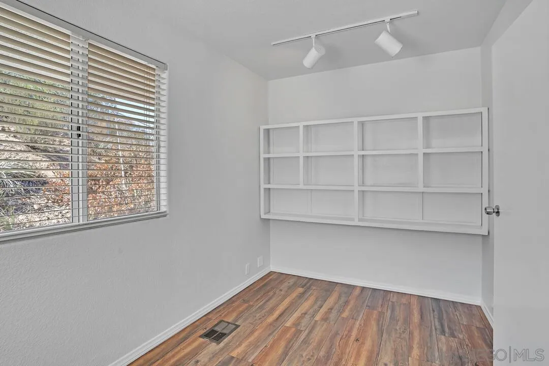 12040 Rocoso Road Lakeside, CA 92040 - Photo 21 of 56 a view of an empty room with a window and wooden floor