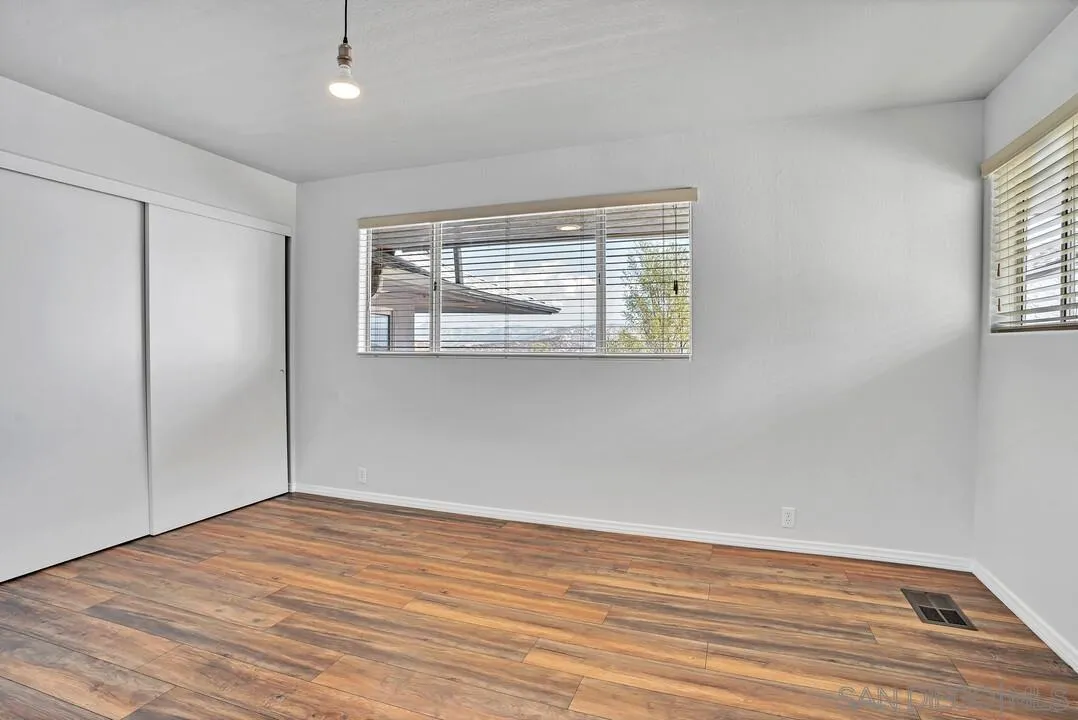 12040 Rocoso Road Lakeside, CA 92040 - Photo 32 of 56 an empty room with wooden floor and windows