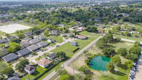 an aerial view of residential houses with outdoor space and trees