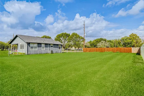 a view of house with garden and a car park in front of it
