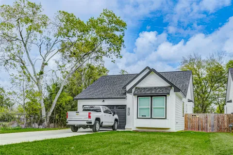 a front view of a house with a yard and a garden