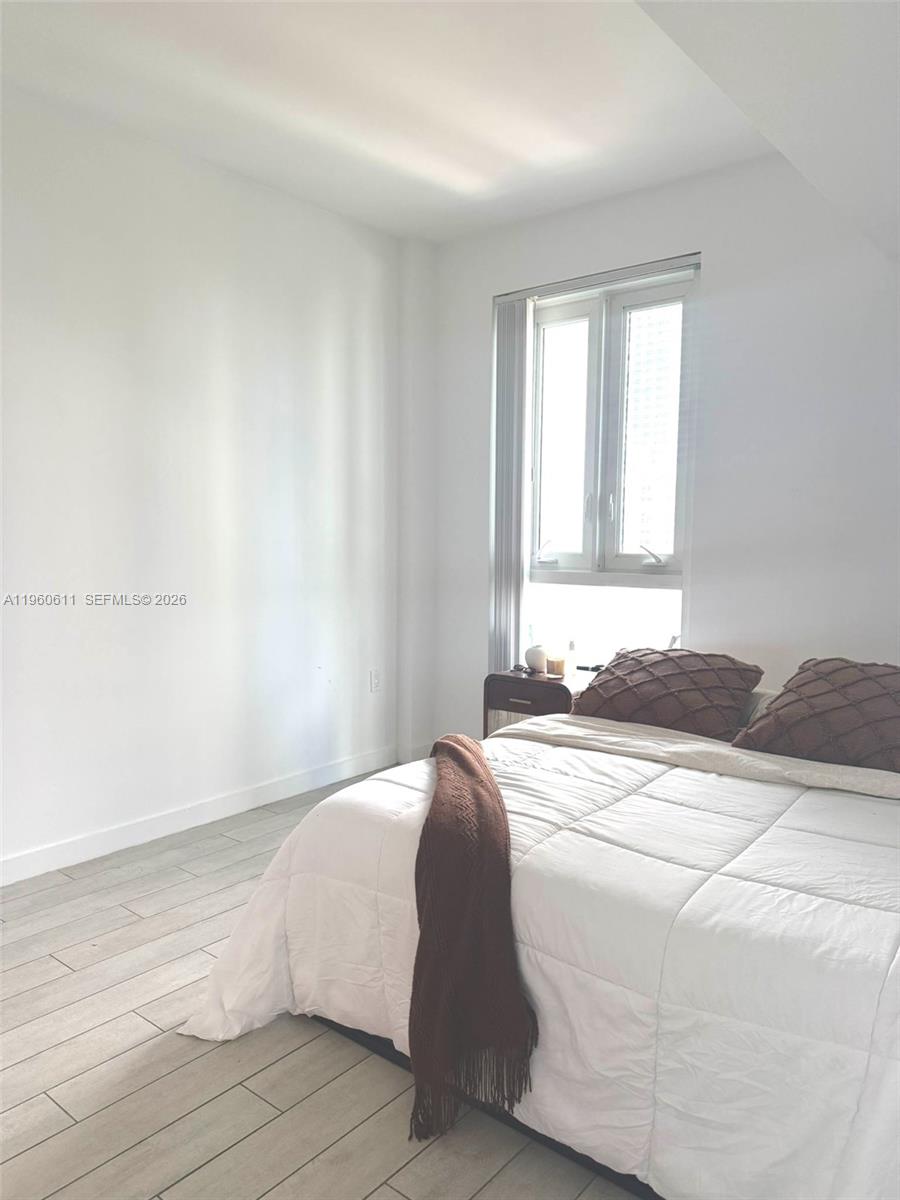 321 Northeast 26th Street, Unit 701 Miami, FL 33137 - Photo 9 of 12 a bedroom with a bed and a window