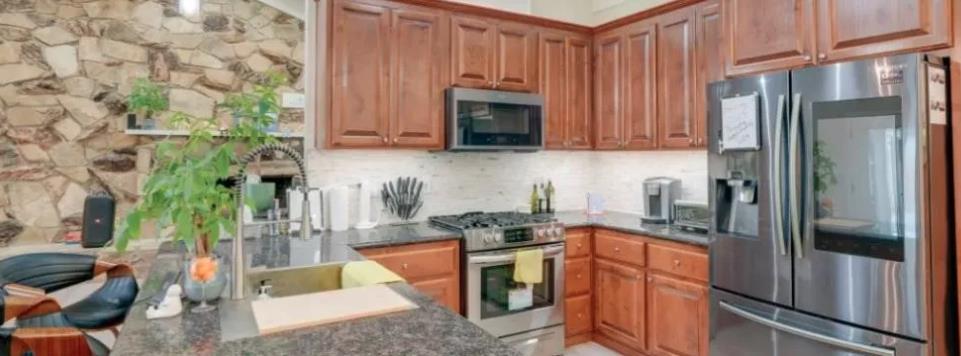 119 San Jose Street Salinas, CA 93901 - Photo 11 of 15 a kitchen with stainless steel appliances granite countertop a refrigerator a stove and a refrigerator with wooden floor