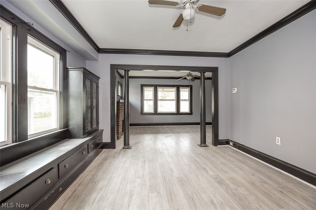 1868-1870 Lampson Road Cleveland, OH 44112 - Photo 6 of 36 Spacious room featuring wood-finish flooring, a ceiling fan, and decorative black trim