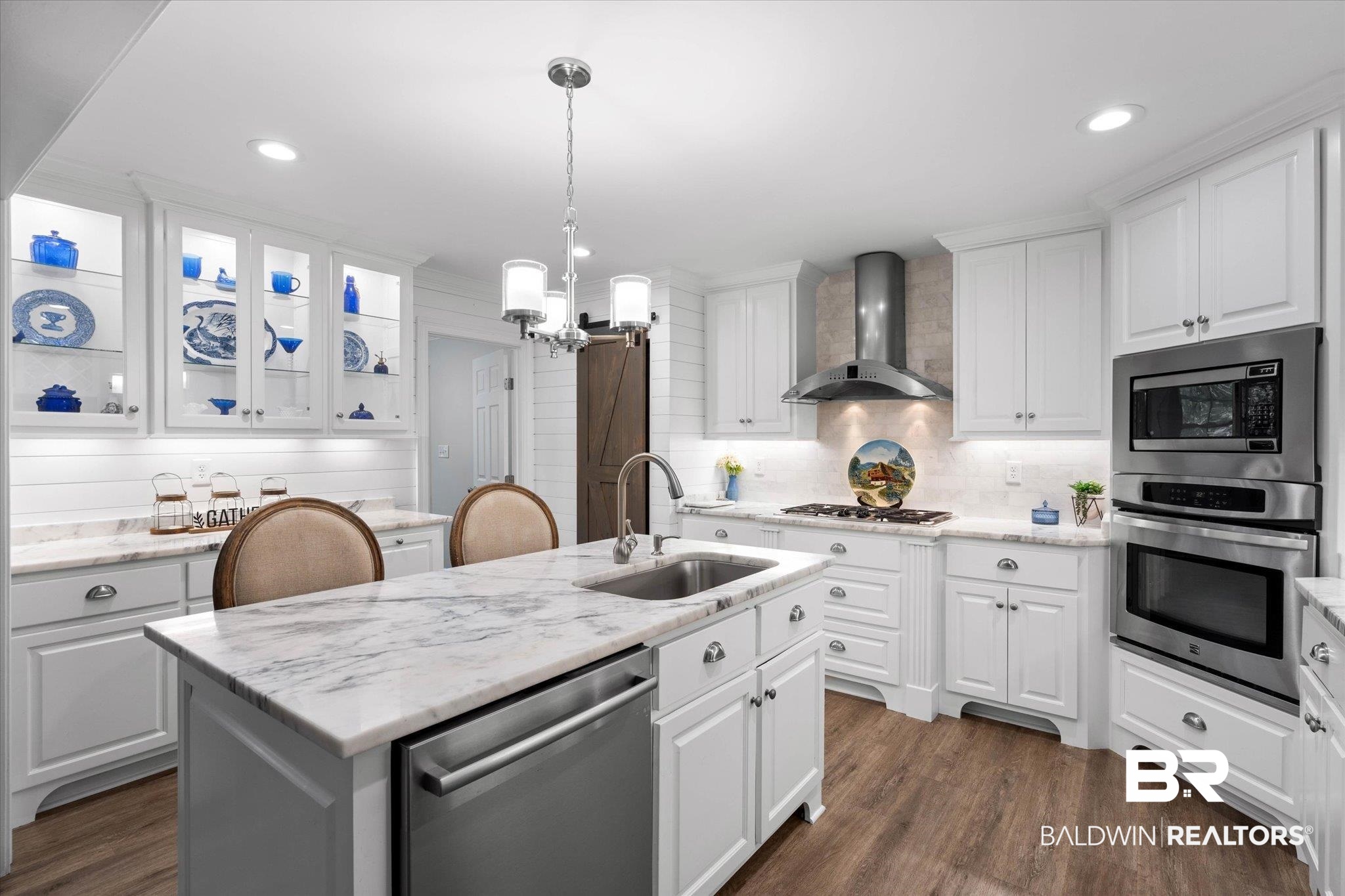 3715 Latigo Road Mobile, AL 36695 - Photo 7 of 39 Kitchen with stainless steel appliances, wall chimney range hood, a sink, white cabinetry, and an island with sink