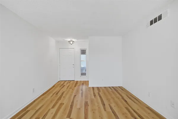 a view of a room with wooden floor and white walls