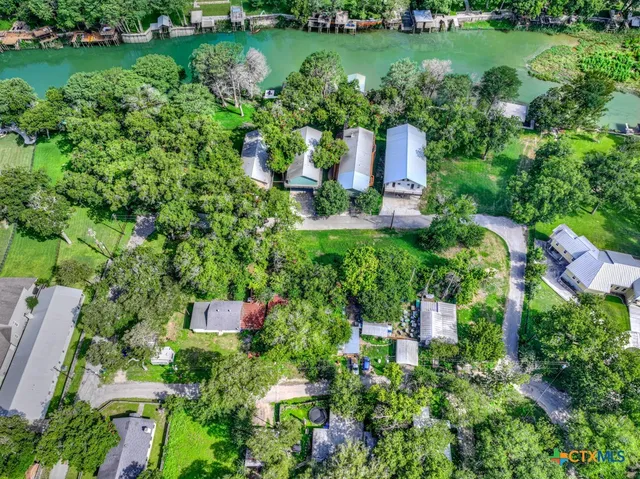 an aerial view of a house with a garden and lake view
