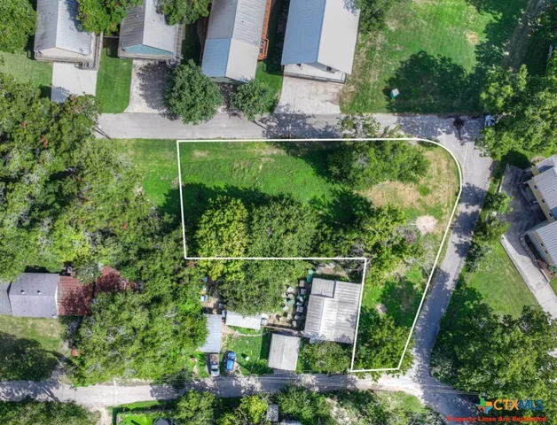 an aerial view of residential houses with outdoor space and street view