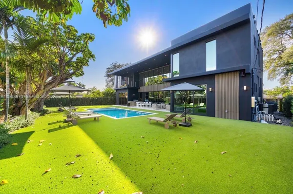 a view of an house with swimming pool and sitting area