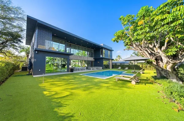 a view of an house with backyard swimming pool and sitting area
