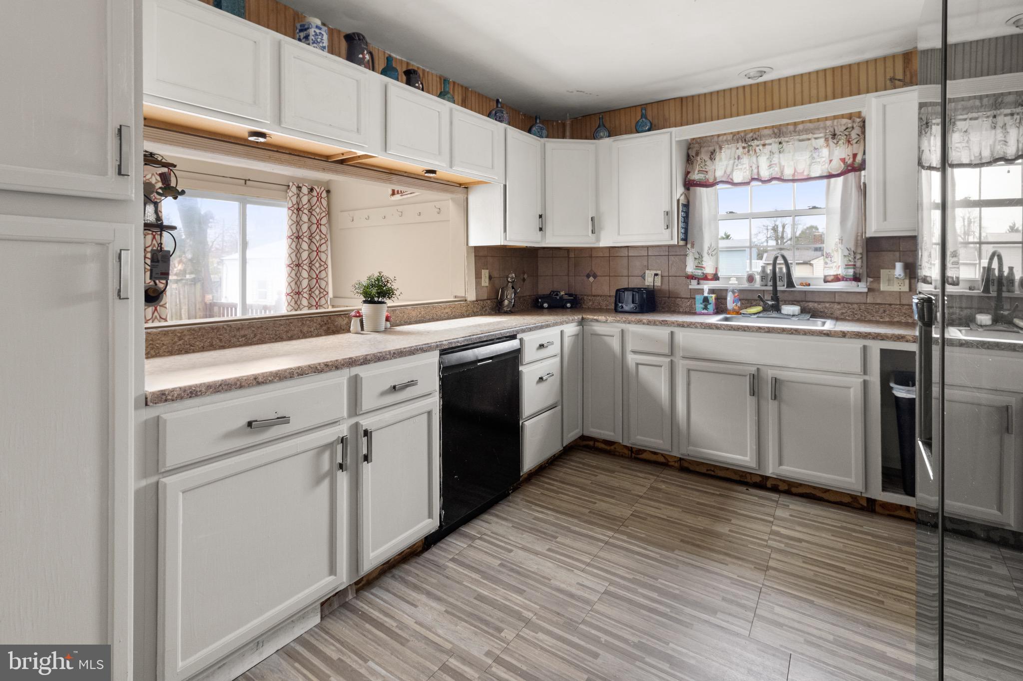 61 Franklin Avenue Clementon, NJ 08021 - Photo 22 of 32 a kitchen with a white cabinets a sink dishwasher and a stove with wooden floor
