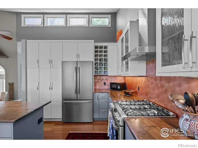 a kitchen with stainless steel appliances granite countertop a refrigerator a stove and a sink