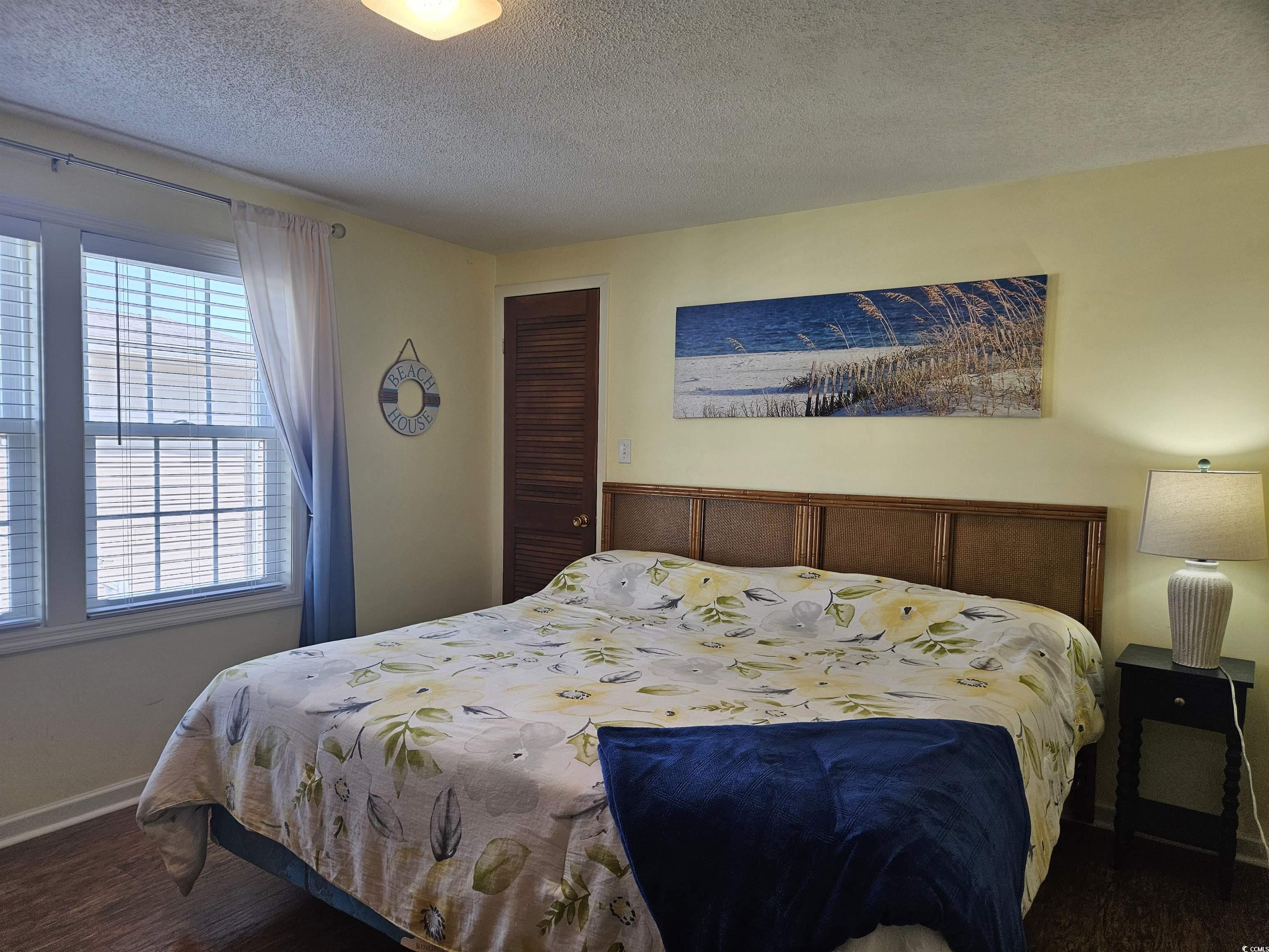 1981 Morning Glory Surfside Beach, SC 29575 - Photo 10 of 22 Bedroom with a textured ceiling, dark wood-type flooring, and a closet