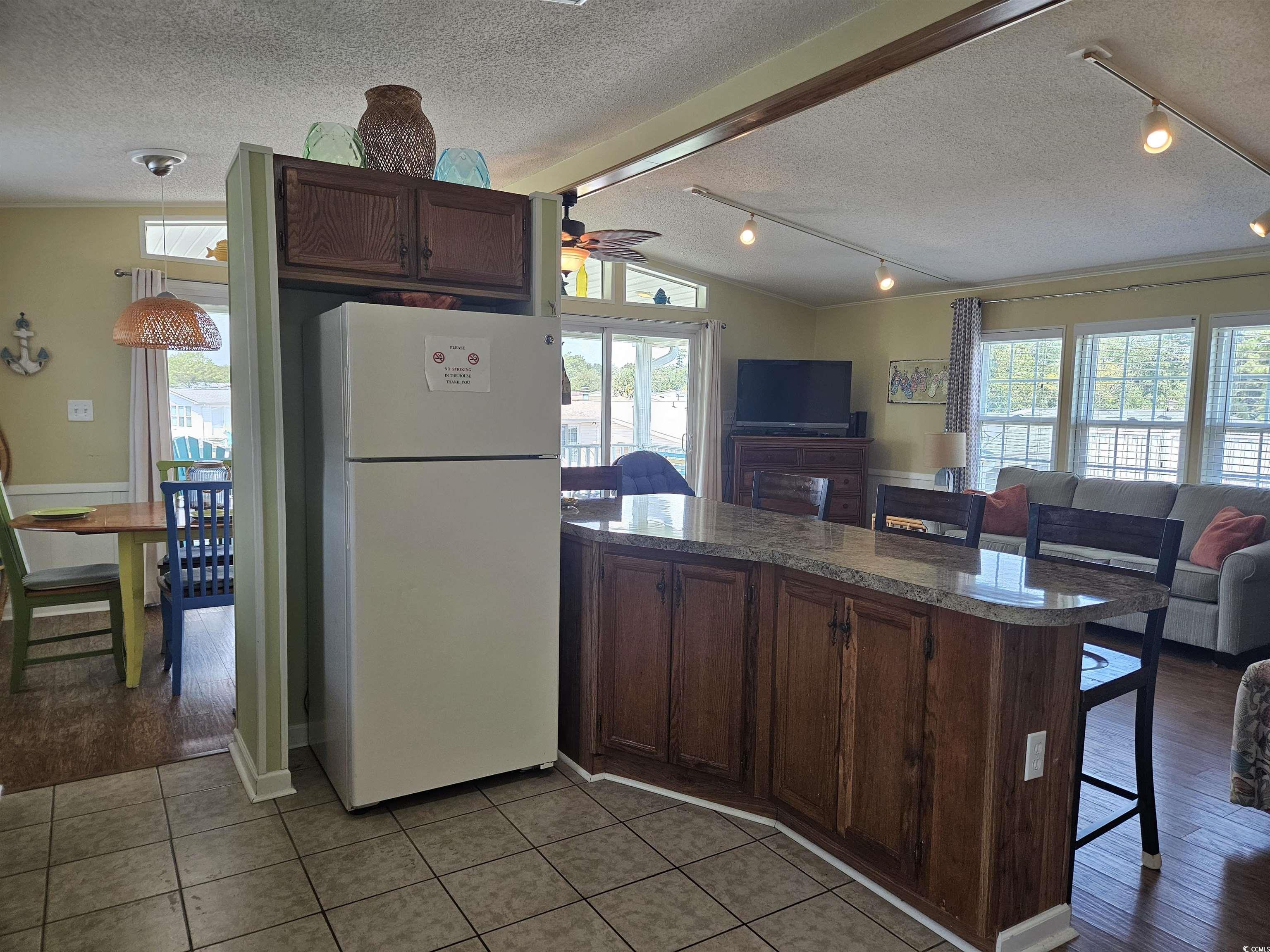 1981 Morning Glory Surfside Beach, SC 29575 - Photo 22 of 22 Kitchen featuring open floor plan, freestanding refrigerator, healthy amount of natural light, a textured ceiling, and lofted ceiling