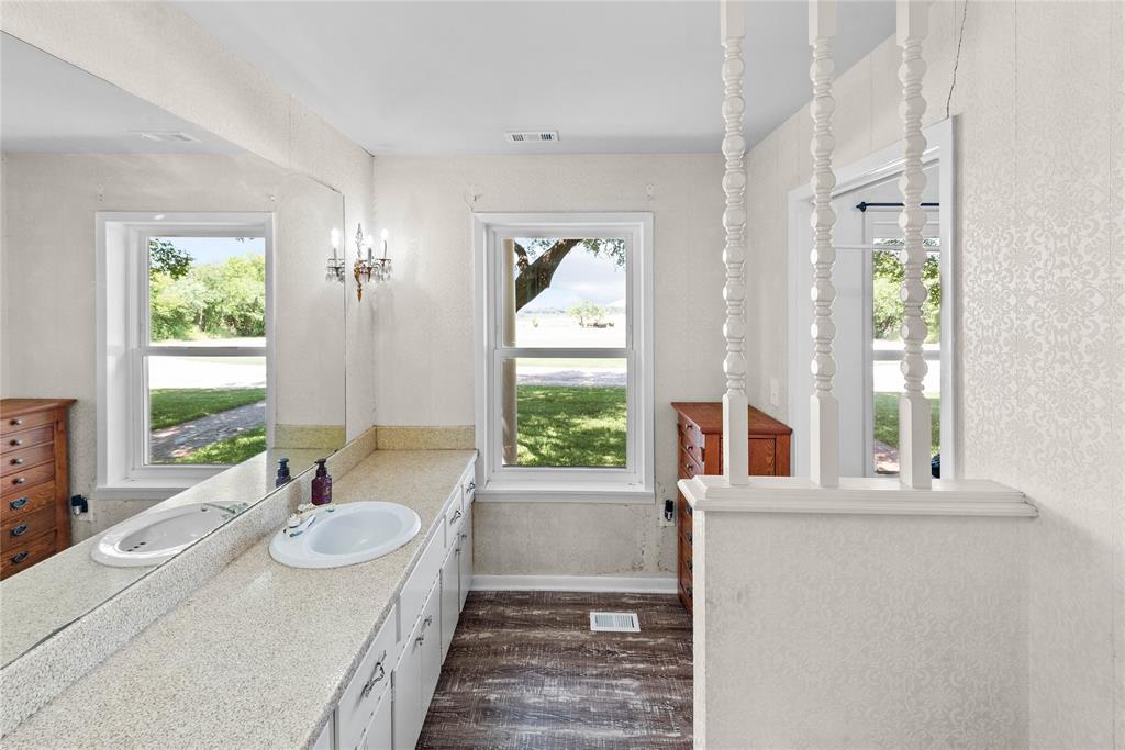 338 HCR 2124 Loop Whitney, TX 76692 - Photo 25 of 39 a bathroom with a granite countertop sink and a large mirror