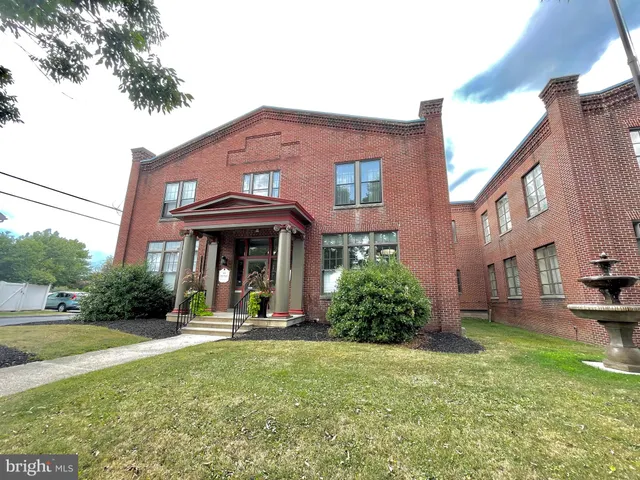a view of a brick house with a yard