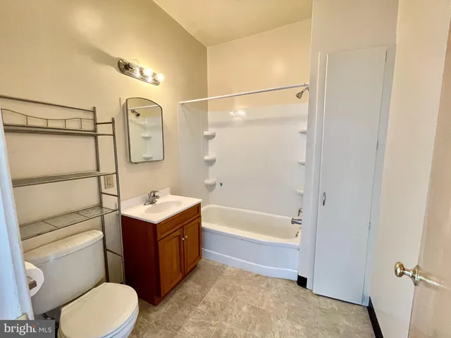 a bathroom with a toilet sink vanity tub and shower