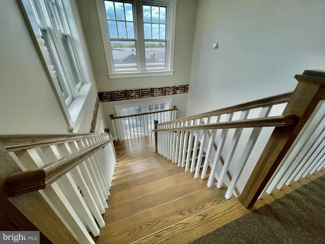 a view of staircase with railing and white walls