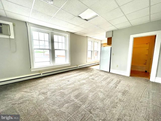 an empty room with cabinet and windows