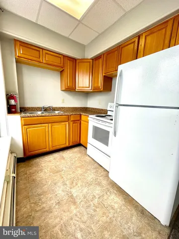 a white refrigerator freezer sitting in a kitchen with stainless steel appliances granite countertop cabinets and a refrigerator