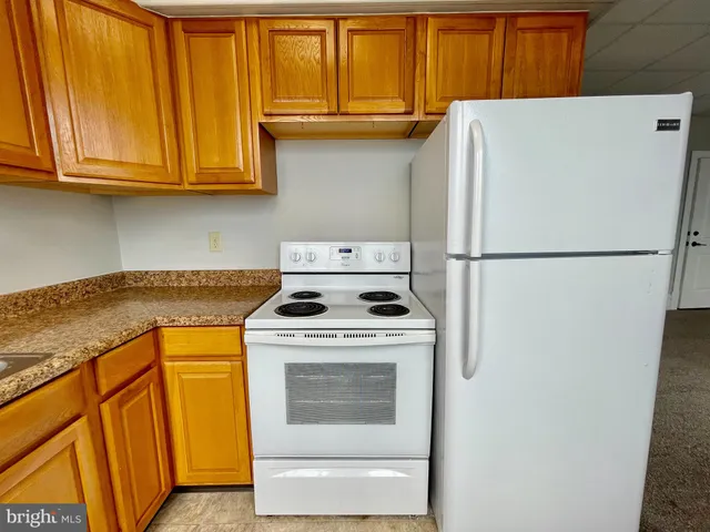 a white refrigerator freezer and a stove sitting inside of a kitchen