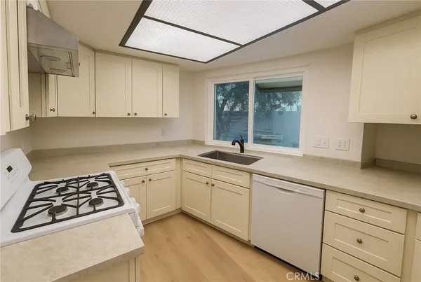 a kitchen with white cabinets and appliances