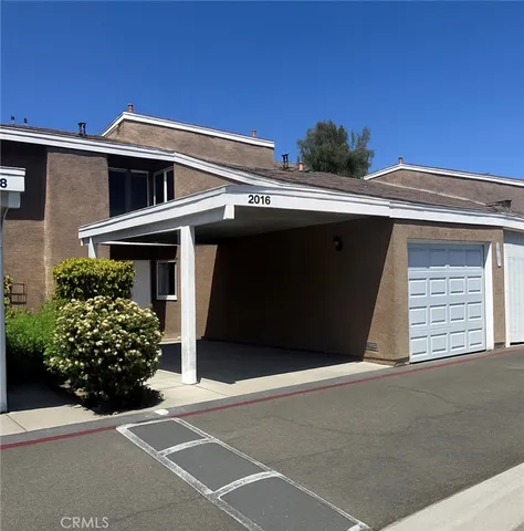 a front view of a house with plants
