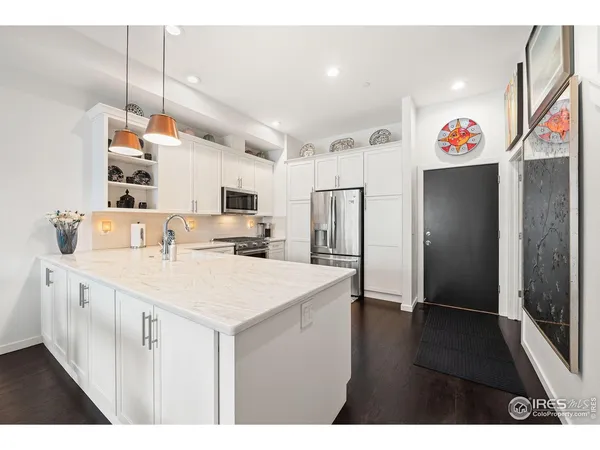a kitchen that has a lot of cabinets a sink and wooden floor