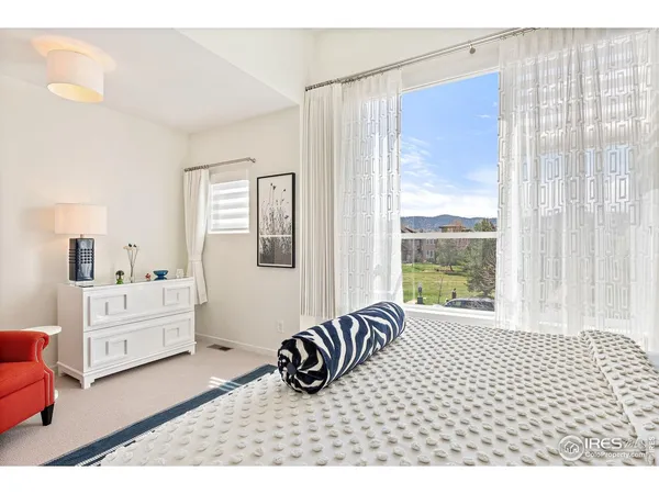 a bedroom with a bed and a large window