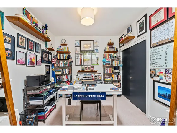 a picture of a living room with a bookshelf and a wooden floor
