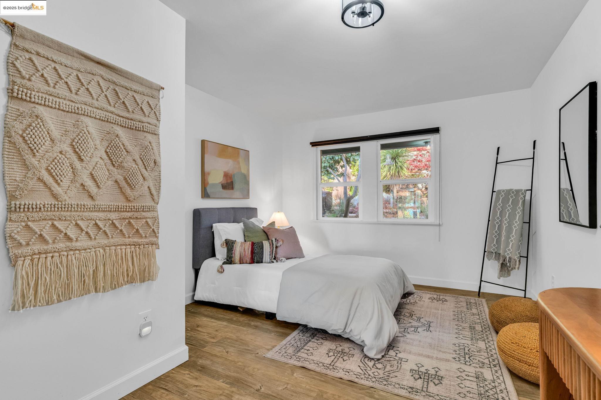 6141 Merriewood Drive Oakland, CA 94611 - Photo 21 of 58 a bedroom with a bed a couch and a window