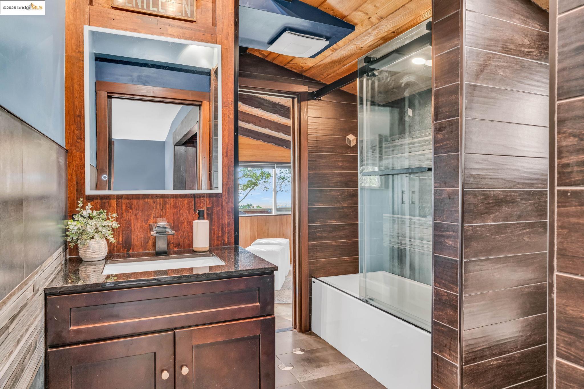 6141 Merriewood Drive Oakland, CA 94611 - Photo 26 of 58 a bathroom with a bathtub and next to a window