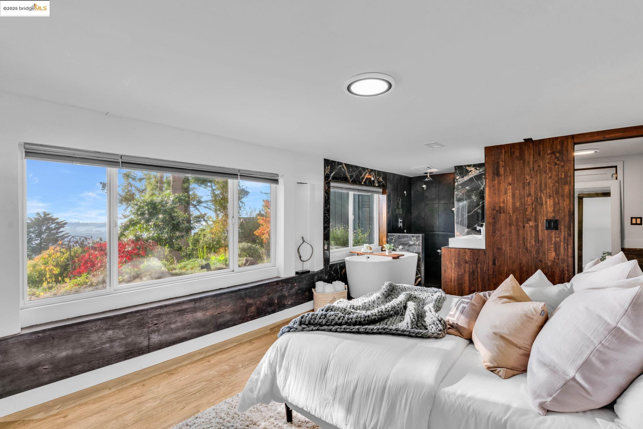 6141 Merriewood Drive Oakland, CA 94611 - Photo 32 of 58 a bedroom with a large bed and a large window with outer view
