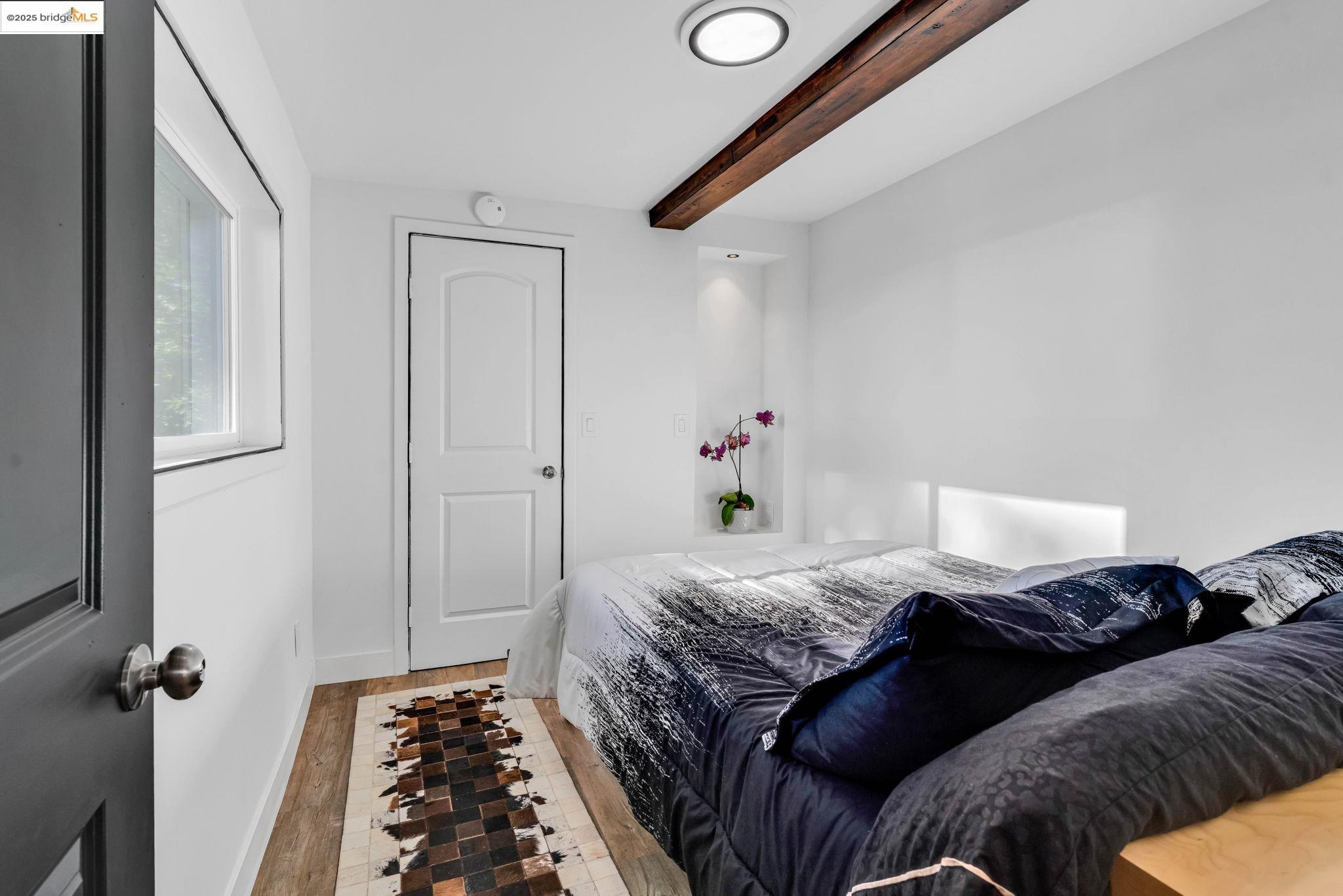 6141 Merriewood Drive Oakland, CA 94611 - Photo 41 of 58 a bedroom with a bed and wooden floor