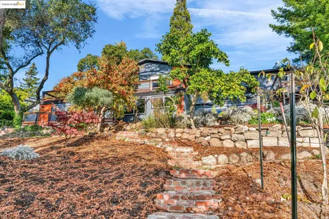 a view of a chair and table in backyard of the house