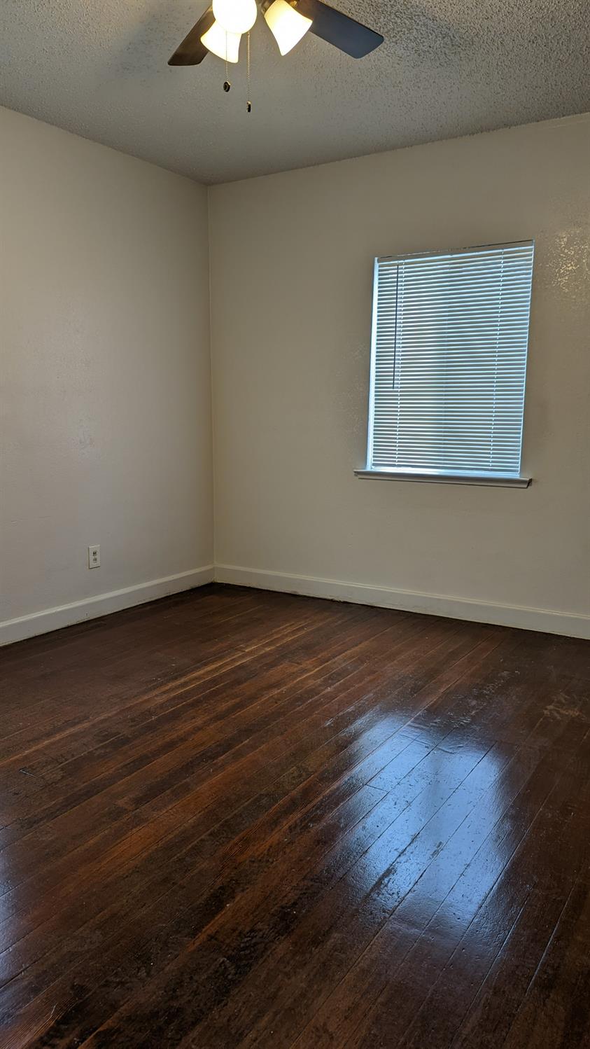 930 Sierra Street Madera, CA 93638 - Photo 12 of 16 a view of an empty room with wooden floor and a chandelier
