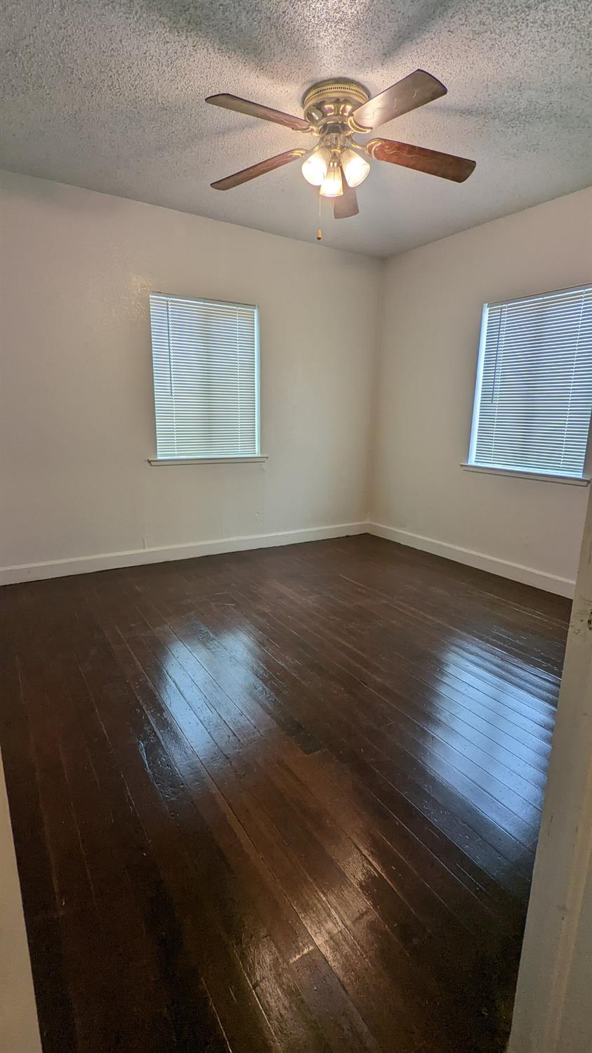 930 Sierra Street Madera, CA 93638 - Photo 7 of 16 a view of an empty room with wooden floor and a window